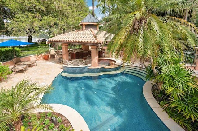 pool with a gazebo, fence, outdoor dry bar, and a patio