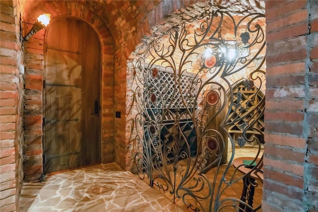 wine room with arched walkways and brick wall