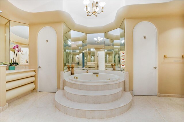 bathroom featuring a whirlpool tub, tile patterned flooring, vanity, and an inviting chandelier