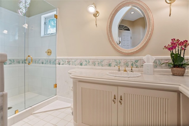 bathroom with wainscoting, a shower stall, tile walls, and vanity