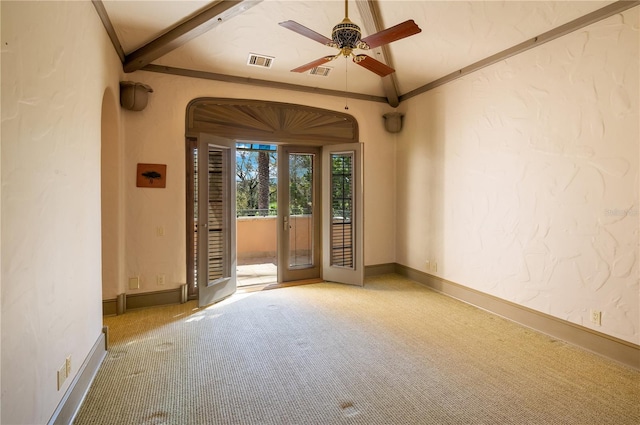 interior space with arched walkways, a textured wall, carpet flooring, visible vents, and baseboards