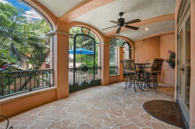 sunroom / solarium featuring lofted ceiling and a ceiling fan