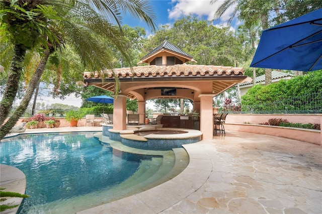 outdoor pool with a patio area, fence, outdoor dry bar, and a gazebo