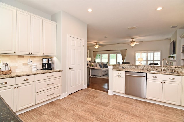 kitchen featuring dishwasher, sink, decorative backsplash, ceiling fan, and white cabinets