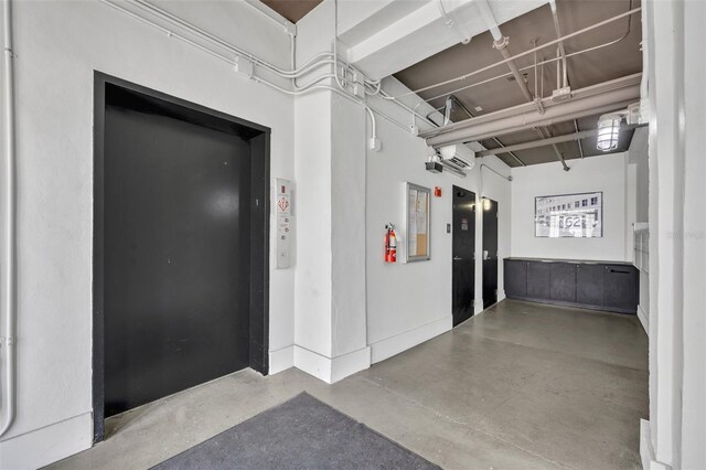 hall featuring concrete flooring and elevator