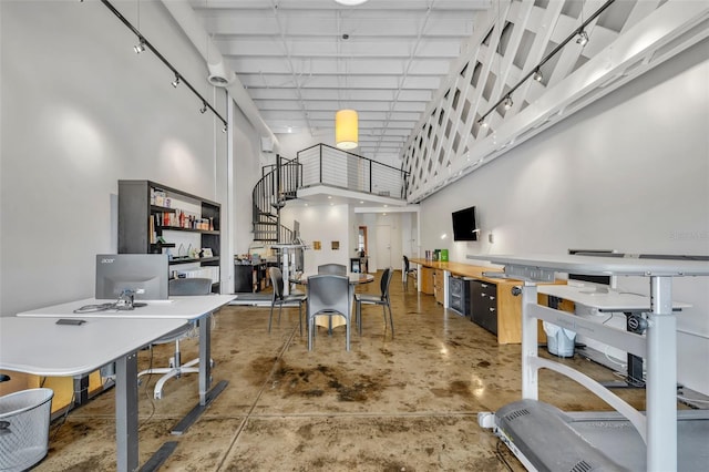 interior space featuring a towering ceiling and concrete floors