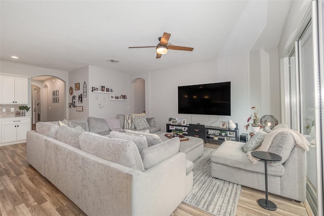 living room with light wood-type flooring and ceiling fan