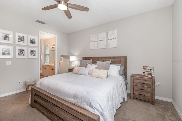 carpeted bedroom with ensuite bath and ceiling fan