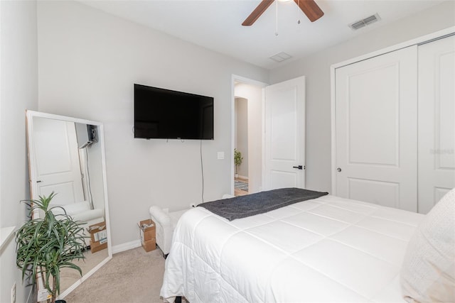 bedroom with ceiling fan, a closet, and light carpet