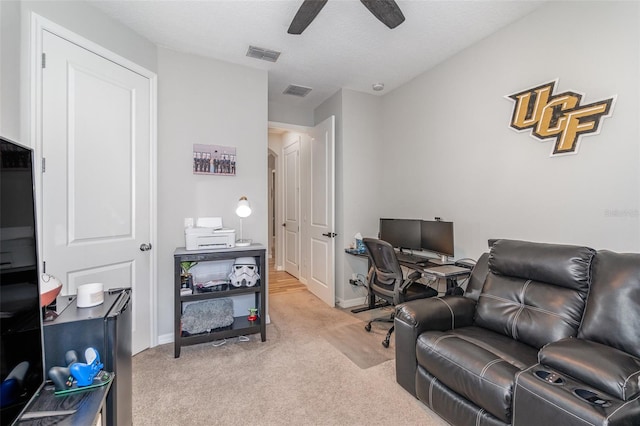 home office featuring a textured ceiling, light colored carpet, and ceiling fan