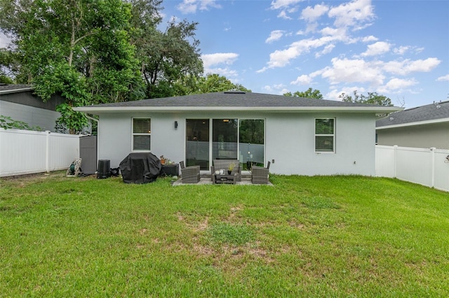 rear view of house with a lawn and a patio