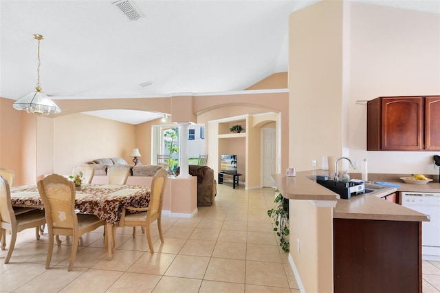 dining space featuring lofted ceiling, sink, light tile patterned floors, and ornate columns