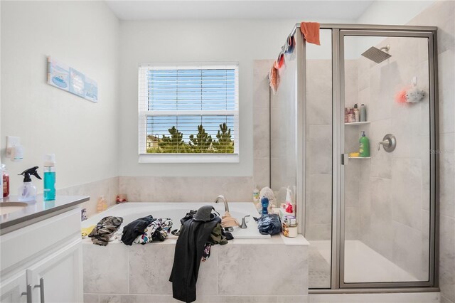 bathroom featuring vanity and independent shower and bath