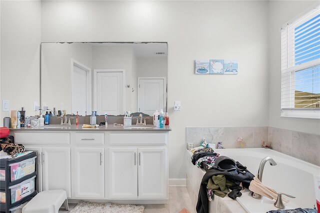 bathroom featuring tile patterned flooring, a bathtub, and vanity