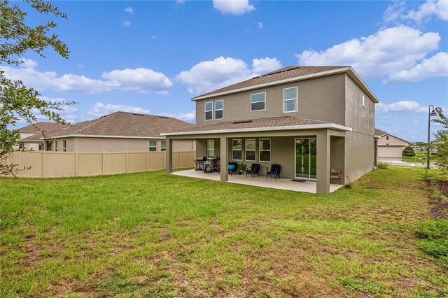 rear view of property featuring a yard and a patio