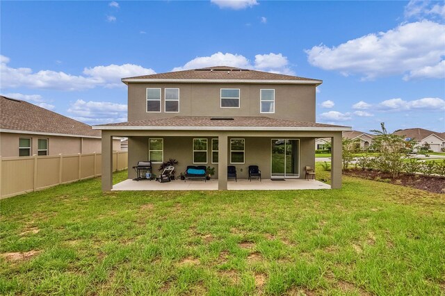 back of house with a lawn and a patio