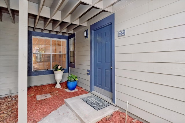 view of exterior entry featuring covered porch