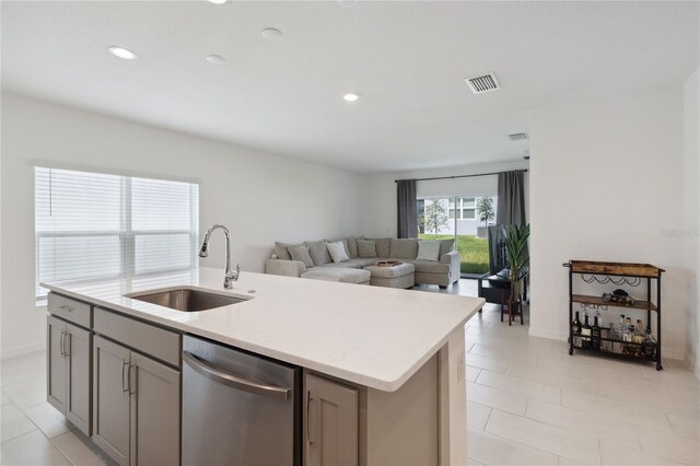 kitchen with gray cabinets, sink, a kitchen island with sink, and stainless steel dishwasher