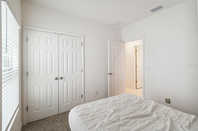 bedroom featuring light carpet and a closet