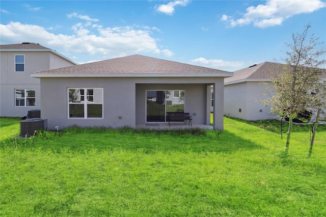 back of property with a lawn and central AC unit