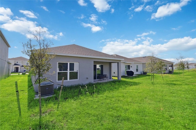 back of property featuring a lawn, a patio, and central AC