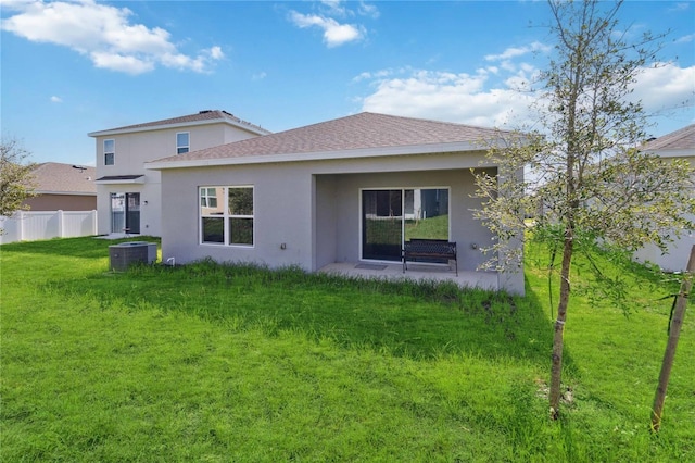 back of property featuring a yard and central air condition unit