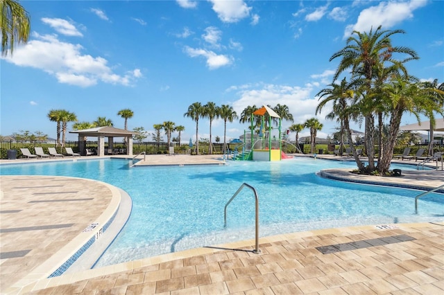 view of swimming pool with pool water feature and a playground