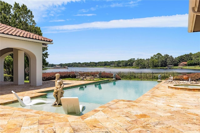 view of swimming pool with a fenced in pool, a patio, a water view, fence, and an in ground hot tub