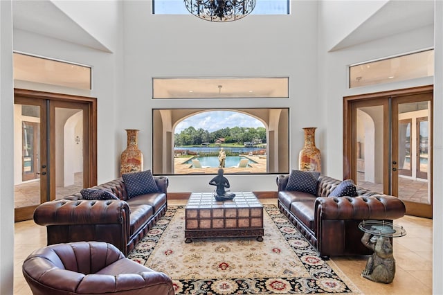 living area with french doors, light tile patterned flooring, and a towering ceiling