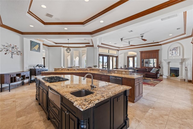 kitchen with visible vents, open floor plan, a sink, and a large island with sink