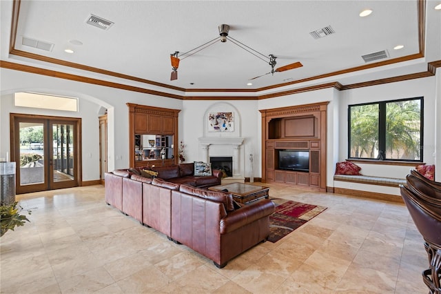 living room with a glass covered fireplace, visible vents, and crown molding