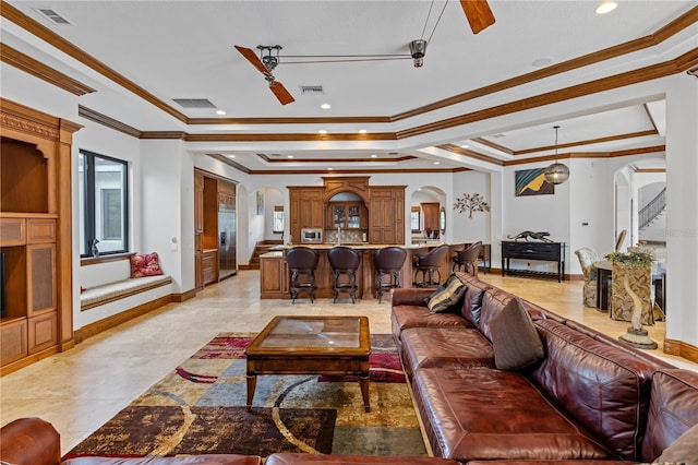 living room featuring a ceiling fan, arched walkways, visible vents, and a tray ceiling