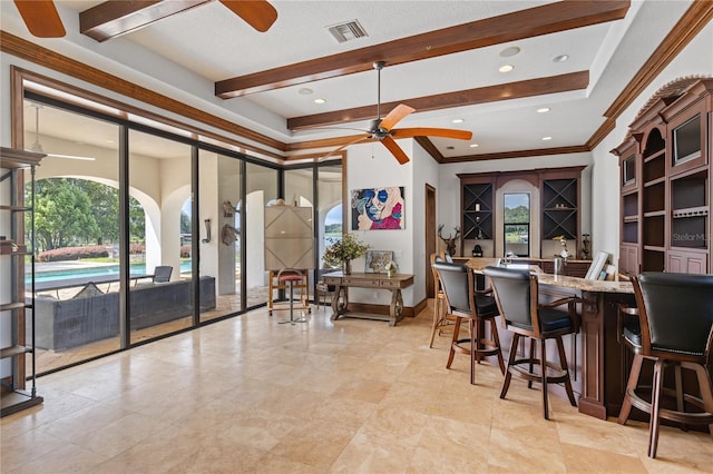 interior space featuring a ceiling fan, wet bar, visible vents, and beamed ceiling