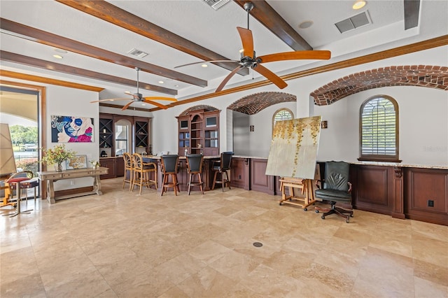 interior space with beam ceiling, wainscoting, visible vents, and bar