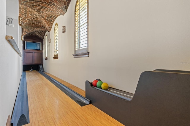 playroom featuring bowling, brick ceiling, vaulted ceiling, and wood finished floors