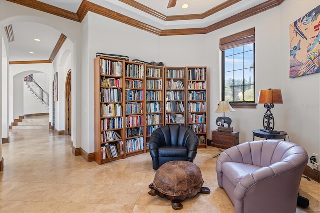 living area featuring baseboards, arched walkways, a ceiling fan, crown molding, and light tile patterned flooring