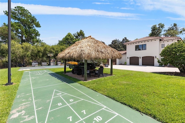 view of home's community featuring a garage, a lawn, a gazebo, and shuffleboard