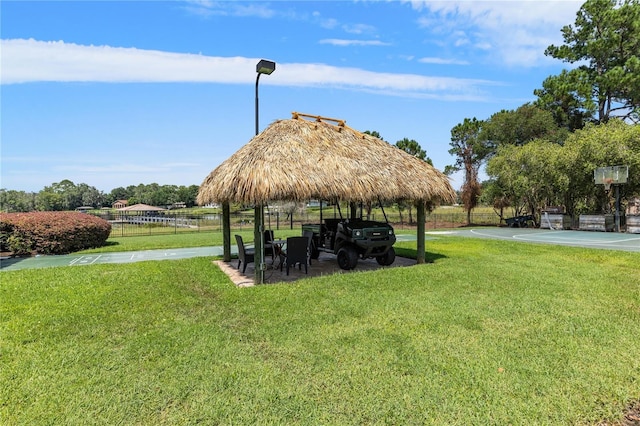 surrounding community featuring community basketball court, a lawn, a gazebo, and fence