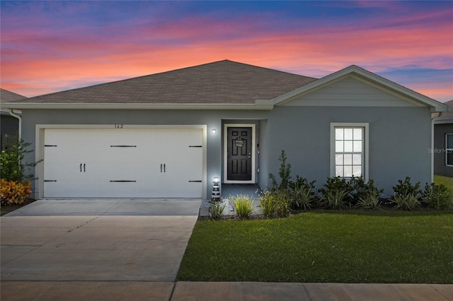 ranch-style home with a lawn and a garage