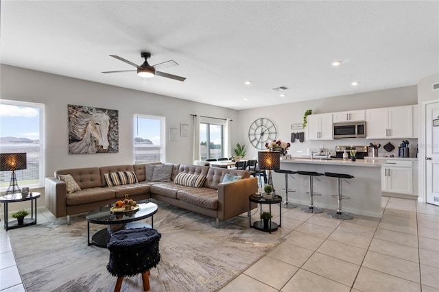 living room featuring ceiling fan and light tile patterned flooring