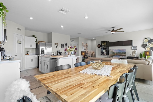 dining space featuring ceiling fan and light tile patterned floors