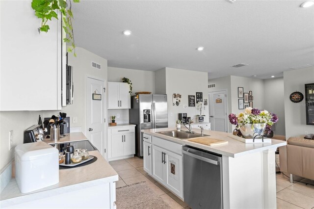 kitchen featuring light tile patterned flooring, sink, an island with sink, white cabinetry, and stainless steel appliances