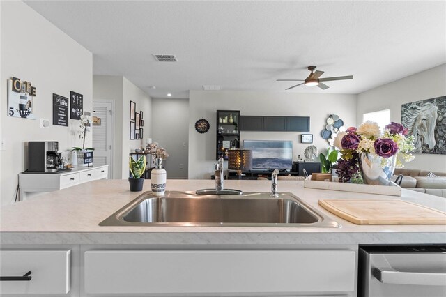 kitchen featuring white cabinetry, ceiling fan, and sink