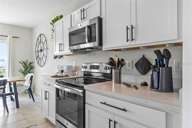 kitchen with white cabinets, stainless steel appliances, and light tile patterned floors