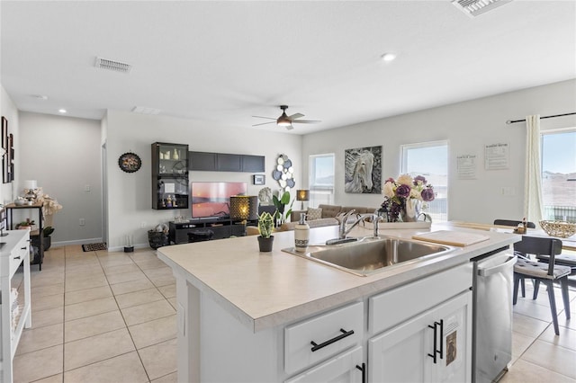 kitchen with ceiling fan, a center island with sink, a healthy amount of sunlight, and stainless steel dishwasher