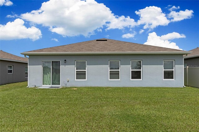 rear view of property with a yard