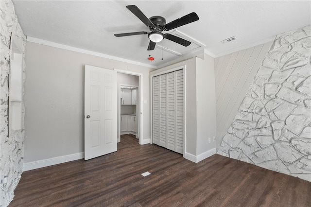 unfurnished bedroom featuring a closet, ceiling fan, dark hardwood / wood-style floors, and crown molding