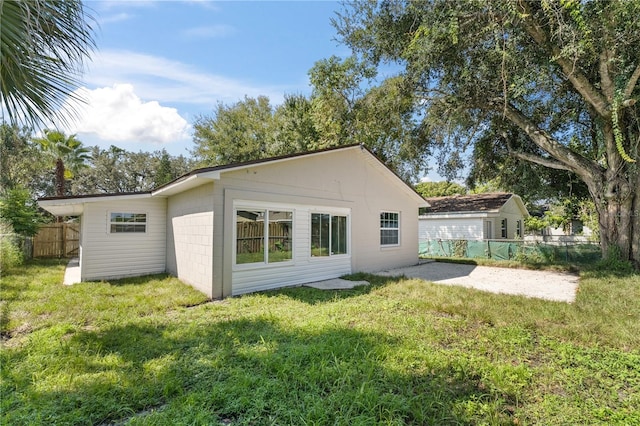 rear view of house with a lawn and an outdoor structure