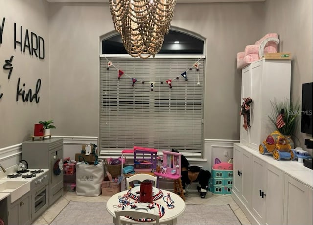 game room featuring a notable chandelier and light tile patterned flooring