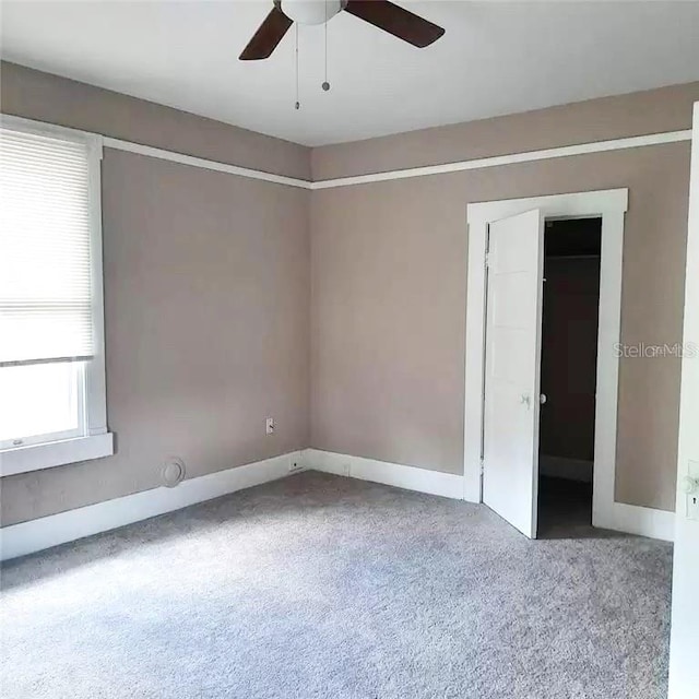 unfurnished room featuring ceiling fan and carpet flooring